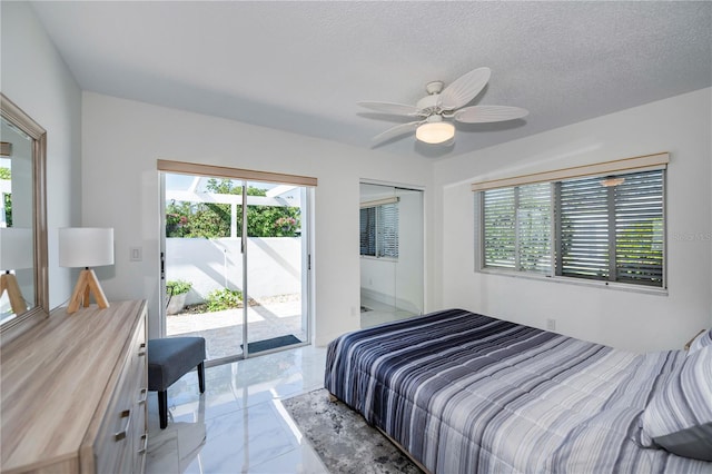 bedroom with access to exterior, ceiling fan, a closet, and a textured ceiling