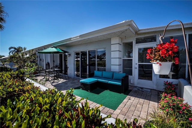 back of property with outdoor lounge area and a patio