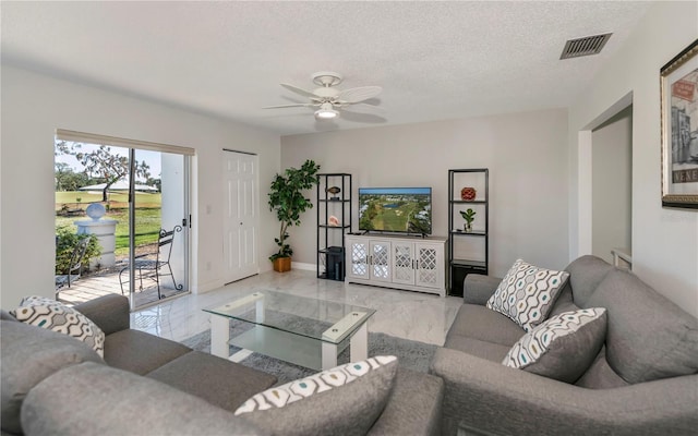 living room featuring a textured ceiling and ceiling fan