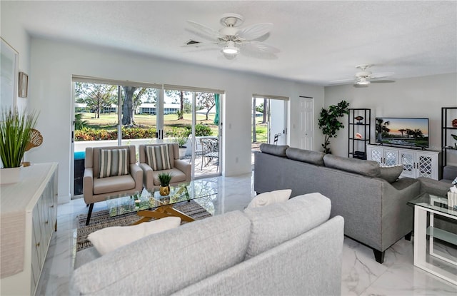 living room featuring a wealth of natural light, ceiling fan, and a textured ceiling