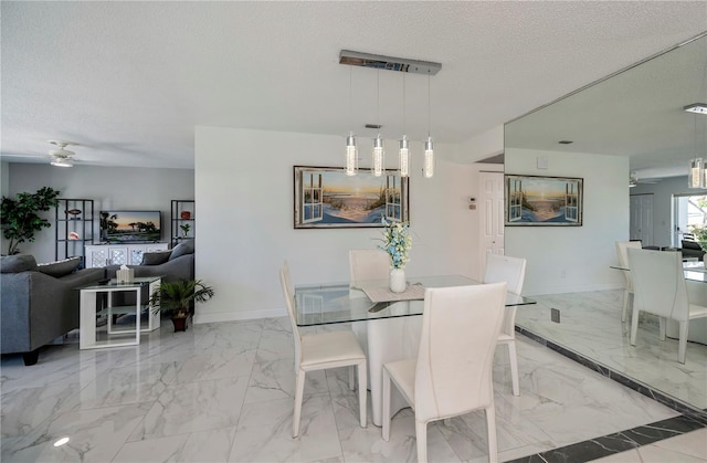 dining space featuring ceiling fan and a textured ceiling