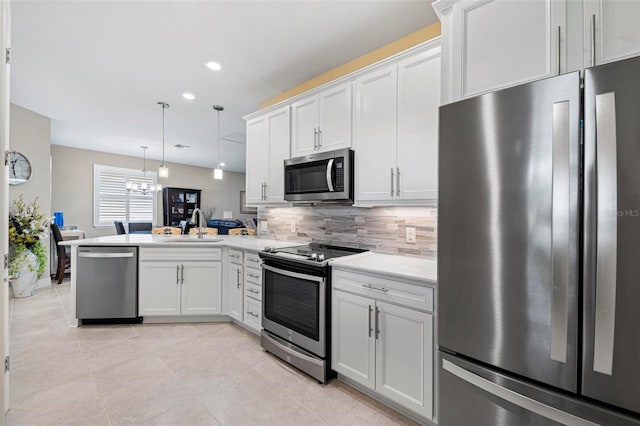 kitchen with white cabinets, sink, hanging light fixtures, tasteful backsplash, and stainless steel appliances