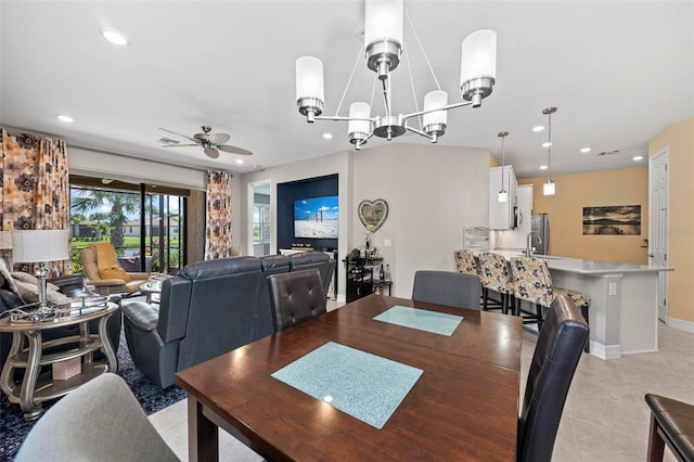 tiled dining area with ceiling fan with notable chandelier