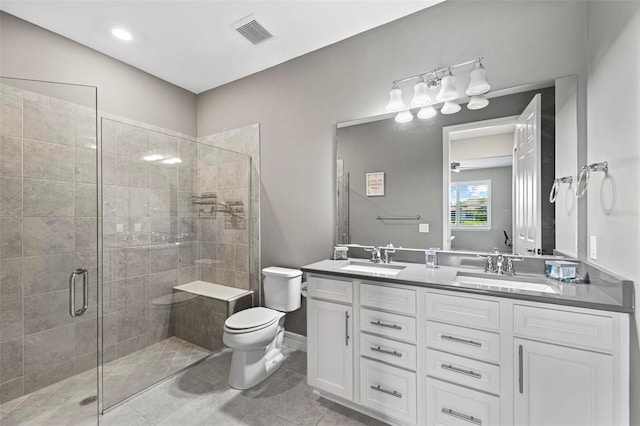 bathroom featuring tile patterned flooring, vanity, toilet, and an enclosed shower