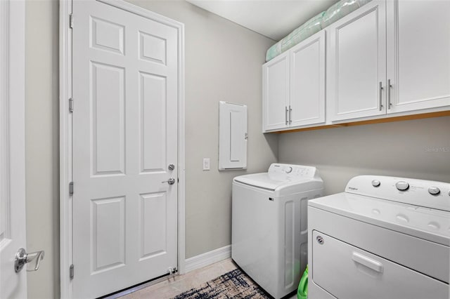 laundry room with cabinets, light tile patterned floors, washing machine and dryer, and electric panel