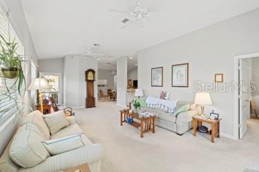 living room featuring light carpet, vaulted ceiling, and ceiling fan