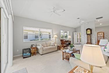 carpeted living room with ceiling fan