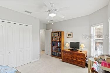 carpeted bedroom featuring multiple windows and ceiling fan