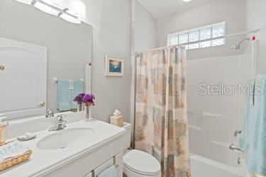 full bathroom with shower / bath combo, toilet, and vanity