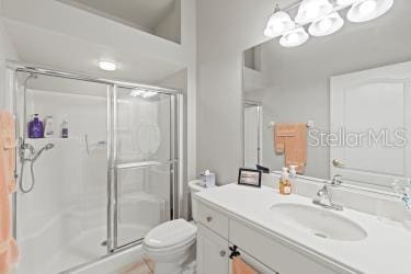 bathroom featuring vanity, toilet, and a shower with shower door