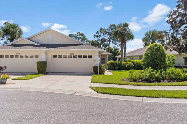 view of front of house featuring an attached garage, driveway, and stucco siding