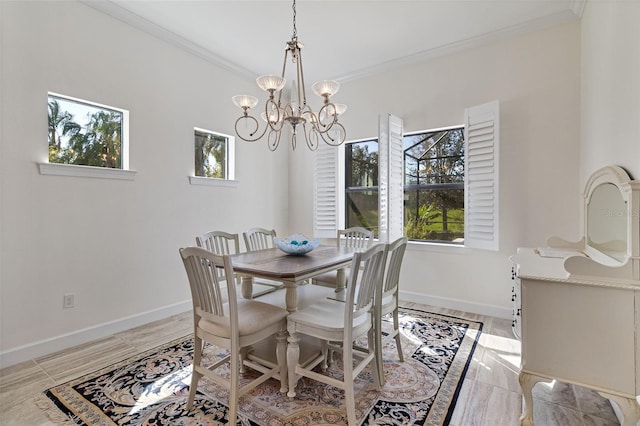 dining room with baseboards, ornamental molding, and a notable chandelier