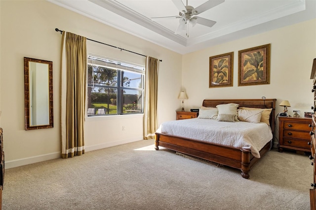 carpeted bedroom featuring ornamental molding, a raised ceiling, baseboards, and a ceiling fan