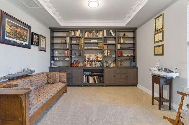 sitting room with visible vents, a tray ceiling, light colored carpet, and crown molding