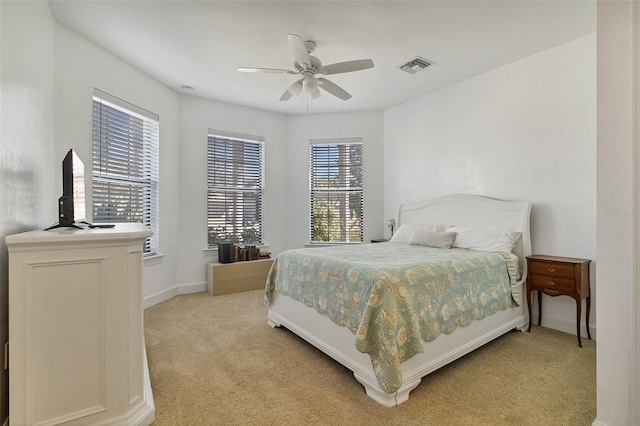 bedroom featuring baseboards, a ceiling fan, visible vents, and light colored carpet