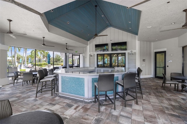 kitchen with open floor plan, high vaulted ceiling, a textured ceiling, and blue cabinets