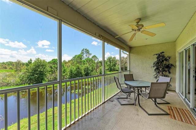 sunroom featuring a water view and ceiling fan