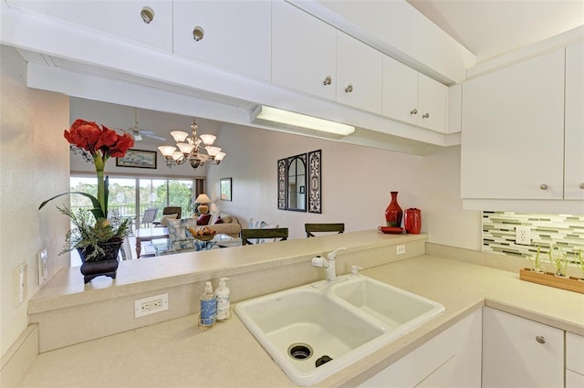 kitchen featuring a sink, white cabinets, light countertops, beam ceiling, and decorative backsplash