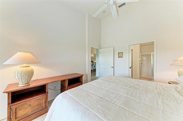 bedroom featuring high vaulted ceiling and ensuite bathroom