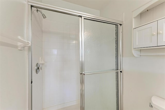 bathroom with toilet and an enclosed shower