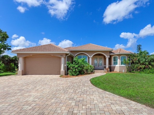 mediterranean / spanish-style home with a front lawn and a garage