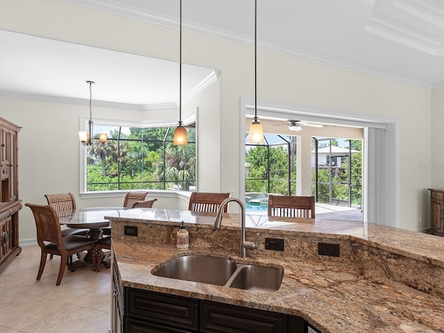 kitchen featuring pendant lighting, crown molding, and sink