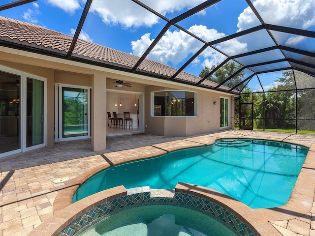 view of swimming pool with ceiling fan, a patio area, glass enclosure, and an in ground hot tub