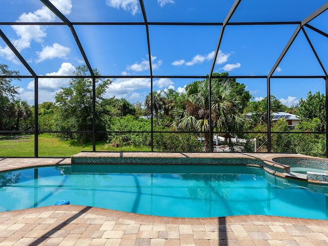 view of pool featuring a lanai and an in ground hot tub