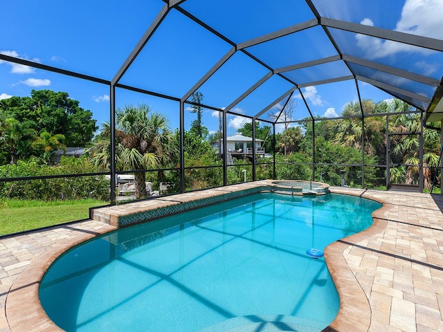 view of pool featuring glass enclosure and an in ground hot tub