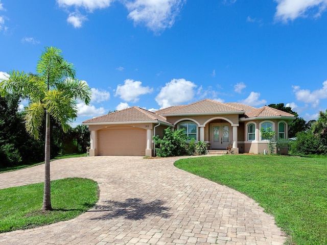 mediterranean / spanish-style house featuring a garage and a front lawn