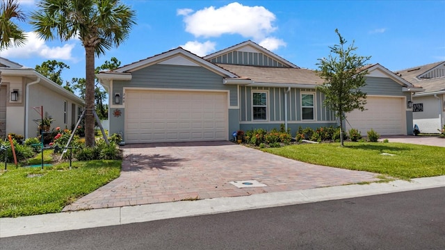 ranch-style house featuring a garage and a front lawn