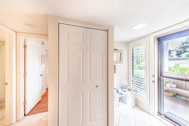 bedroom featuring a textured ceiling, a closet, and light wood-type flooring