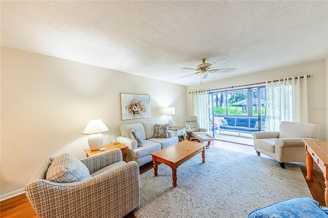 living room featuring a textured ceiling, ceiling fan, and hardwood / wood-style flooring