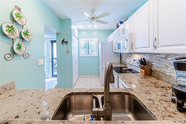 kitchen featuring light tile patterned floors, white appliances, white cabinetry, sink, and ceiling fan