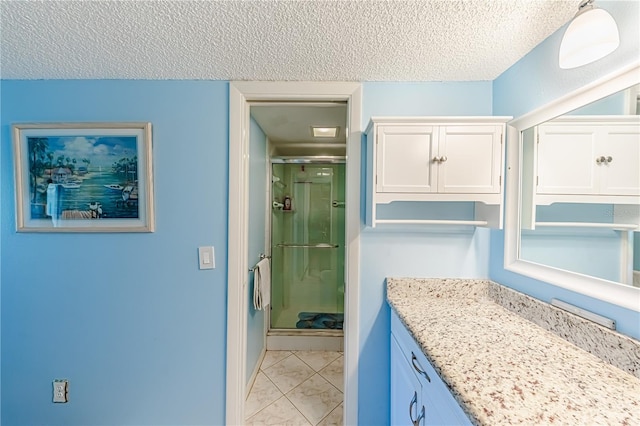 bathroom with an enclosed shower, a textured ceiling, and vanity