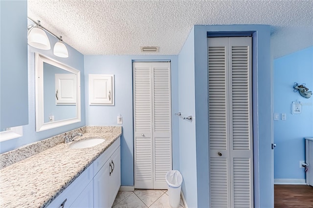 bathroom with vanity, a textured ceiling, and tile patterned floors