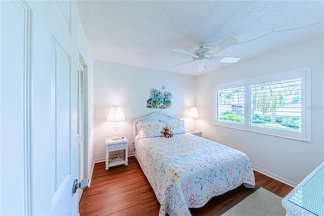 bedroom with a textured ceiling, ceiling fan, a closet, and wood-type flooring