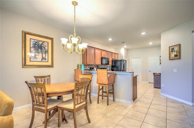 tiled dining space with a chandelier