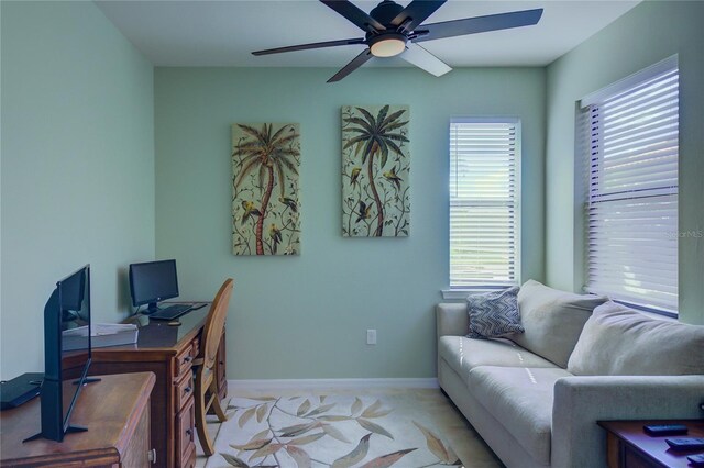 office space featuring baseboards and ceiling fan