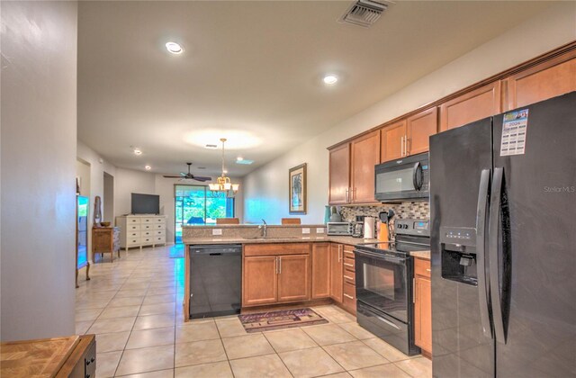 kitchen with open floor plan, black appliances, a peninsula, and brown cabinetry