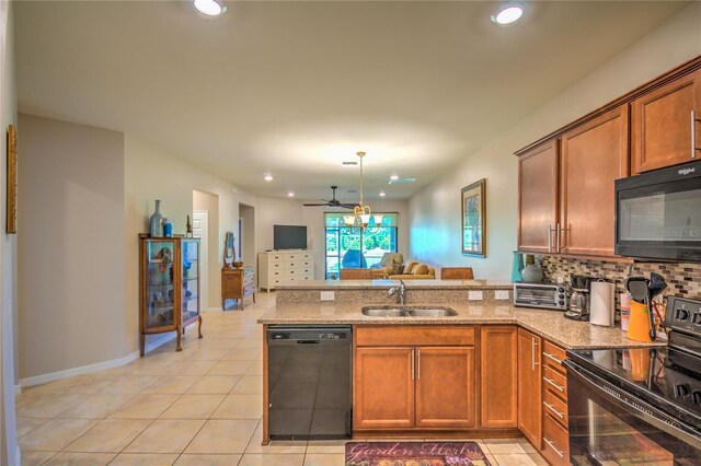 kitchen featuring a peninsula, a sink, decorative backsplash, black appliances, and open floor plan