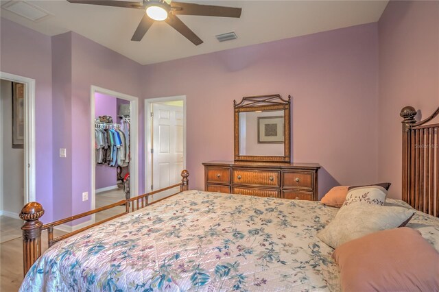 bedroom featuring a closet, ceiling fan, and a walk in closet