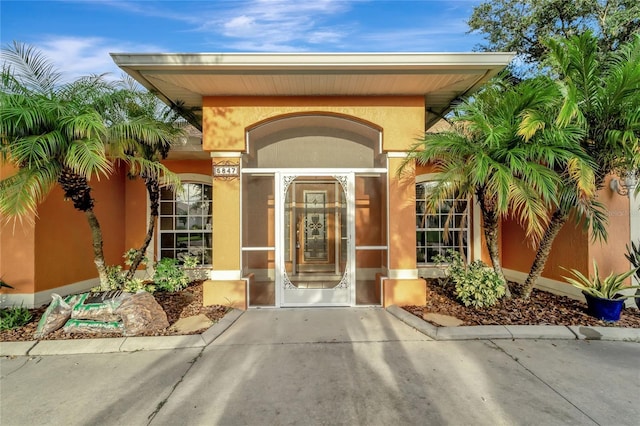 view of exterior entry with stucco siding