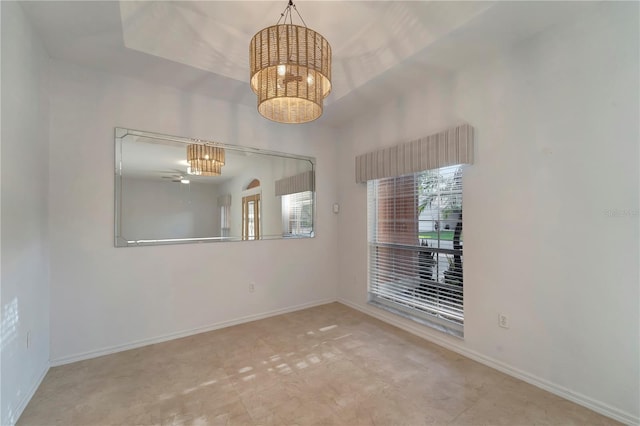 empty room featuring baseboards and a notable chandelier