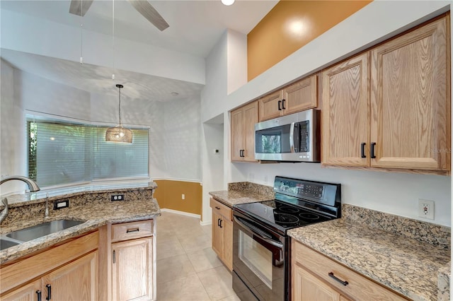 kitchen featuring black / electric stove, a sink, light stone countertops, light brown cabinetry, and stainless steel microwave