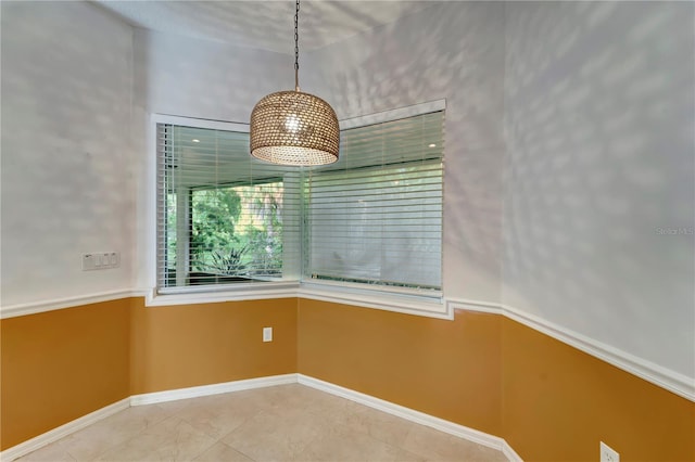 unfurnished dining area featuring tile patterned flooring and baseboards