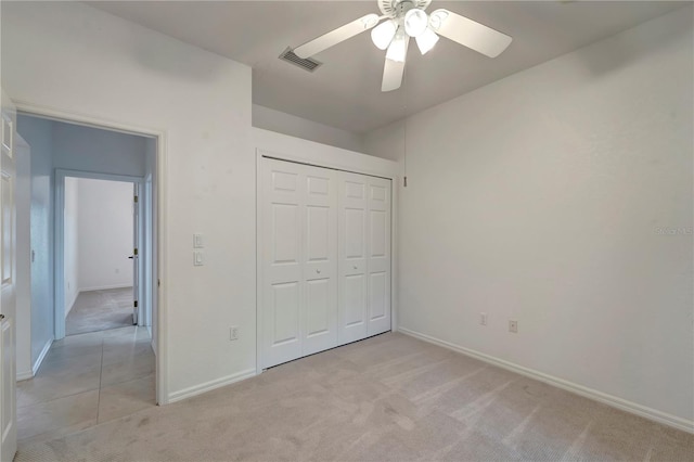 unfurnished bedroom featuring light carpet, baseboards, visible vents, a ceiling fan, and a closet