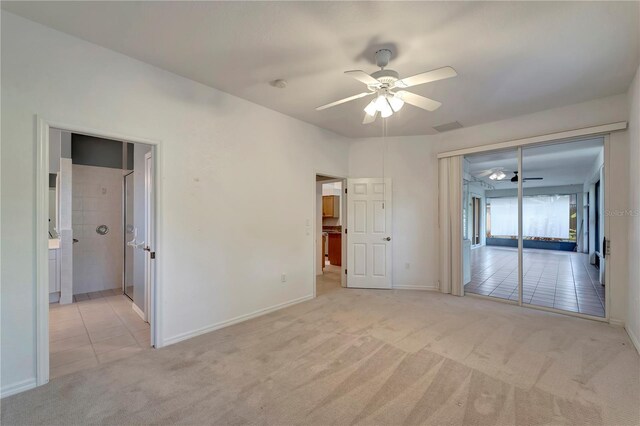 carpeted empty room featuring tile patterned flooring, visible vents, ceiling fan, and baseboards