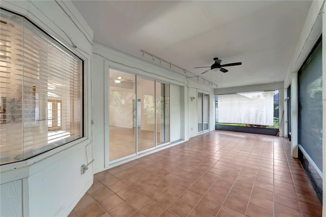 unfurnished sunroom featuring ceiling fan and track lighting