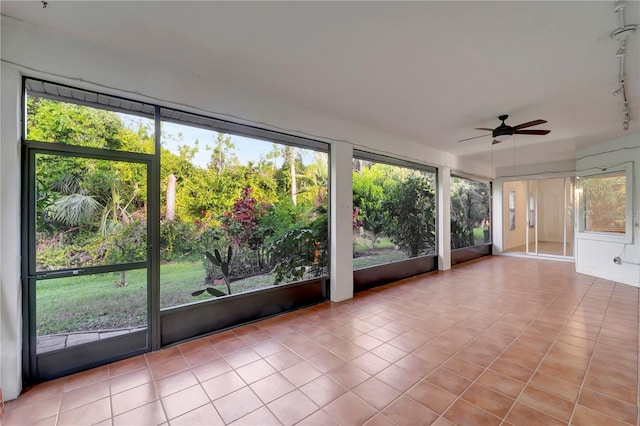 unfurnished sunroom featuring a ceiling fan